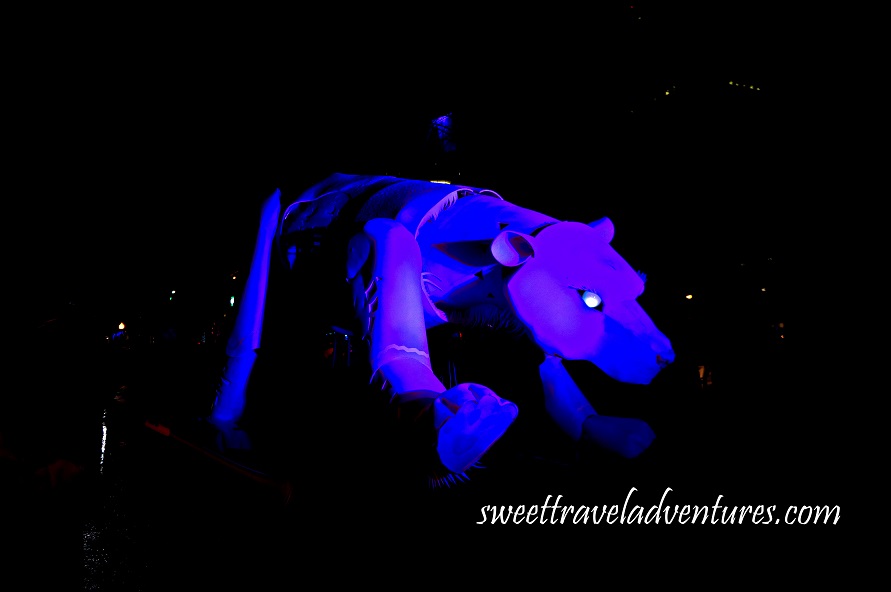 Giant Polar Bear Puppet on the Street at Night Lit a Dark Blue Colour With a Little Bit of Purple